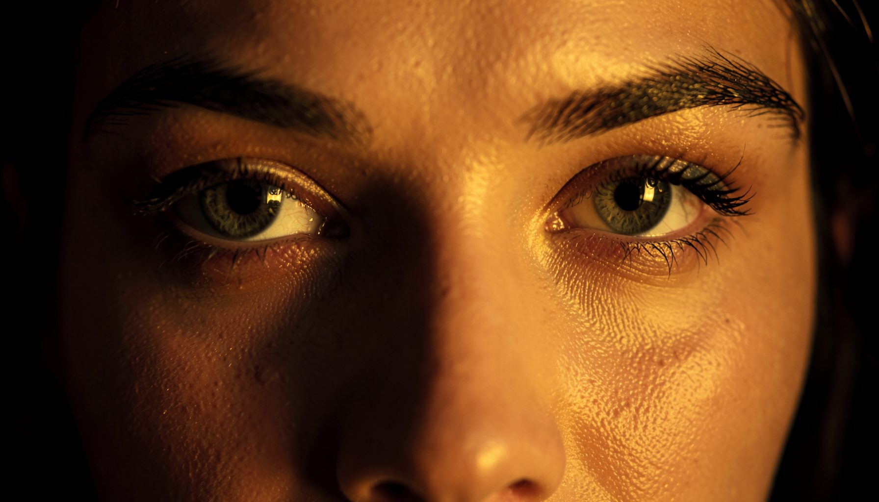 Close-up of expressive, deep-set eyes with warm golden light, rich dark tones and a glamorous, cinematic mood